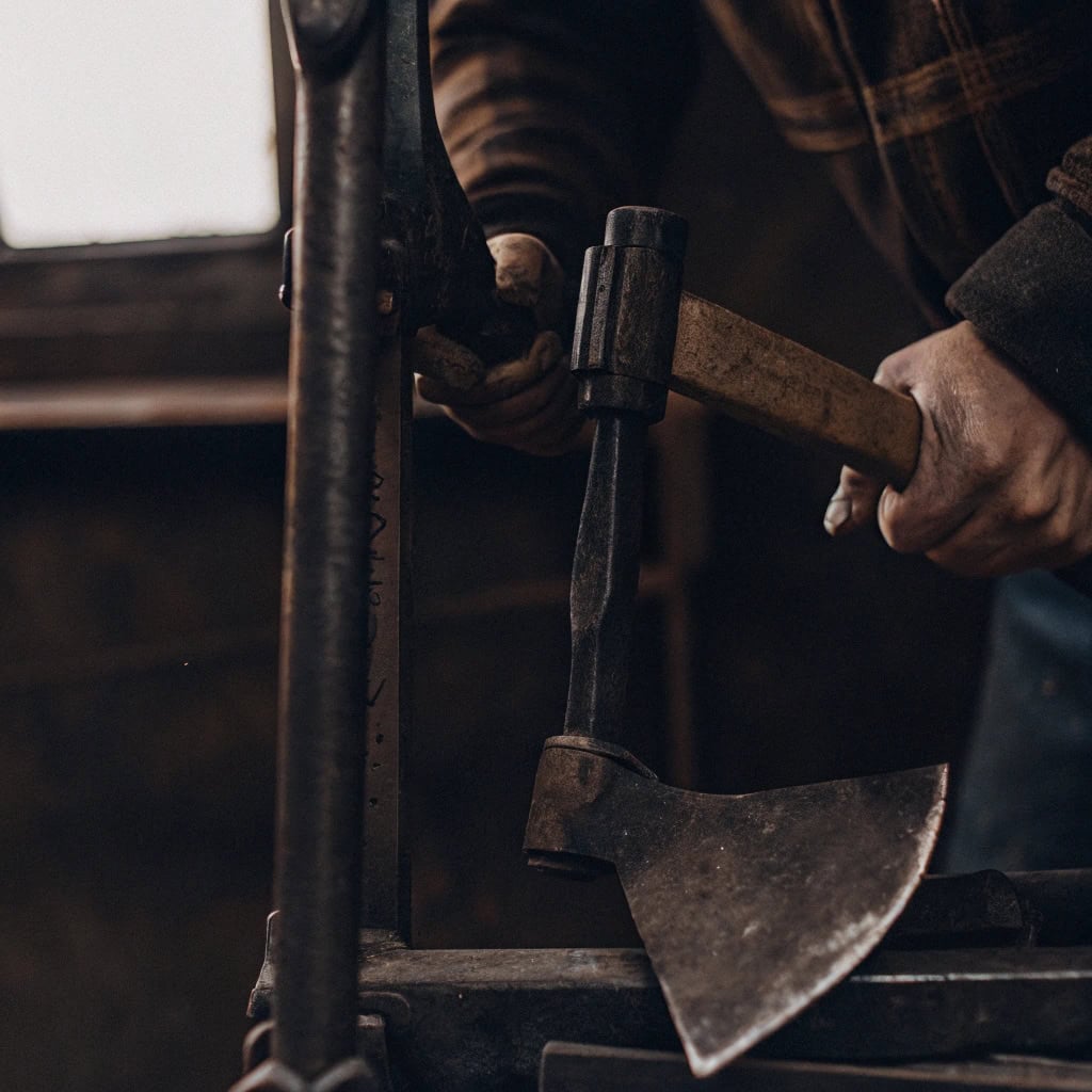 Driving wedges into the top of an axe handle to secure the head