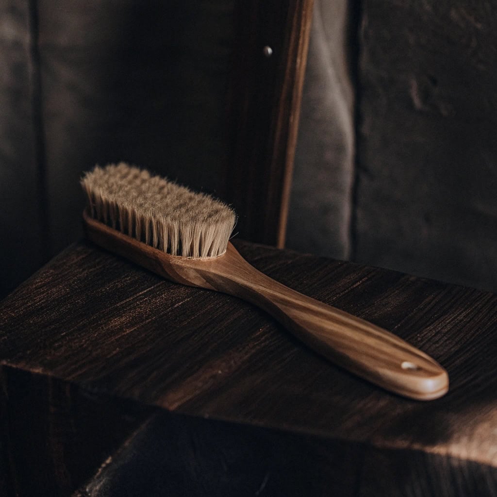Woman smiling while brushing hair smoothly with a wooden brush